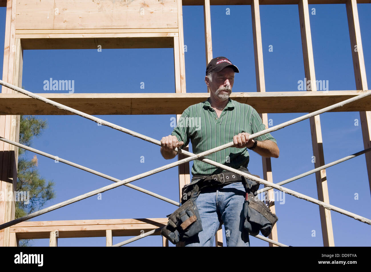 Carpenter standing on scaffolding at a construction site Stock Photo
