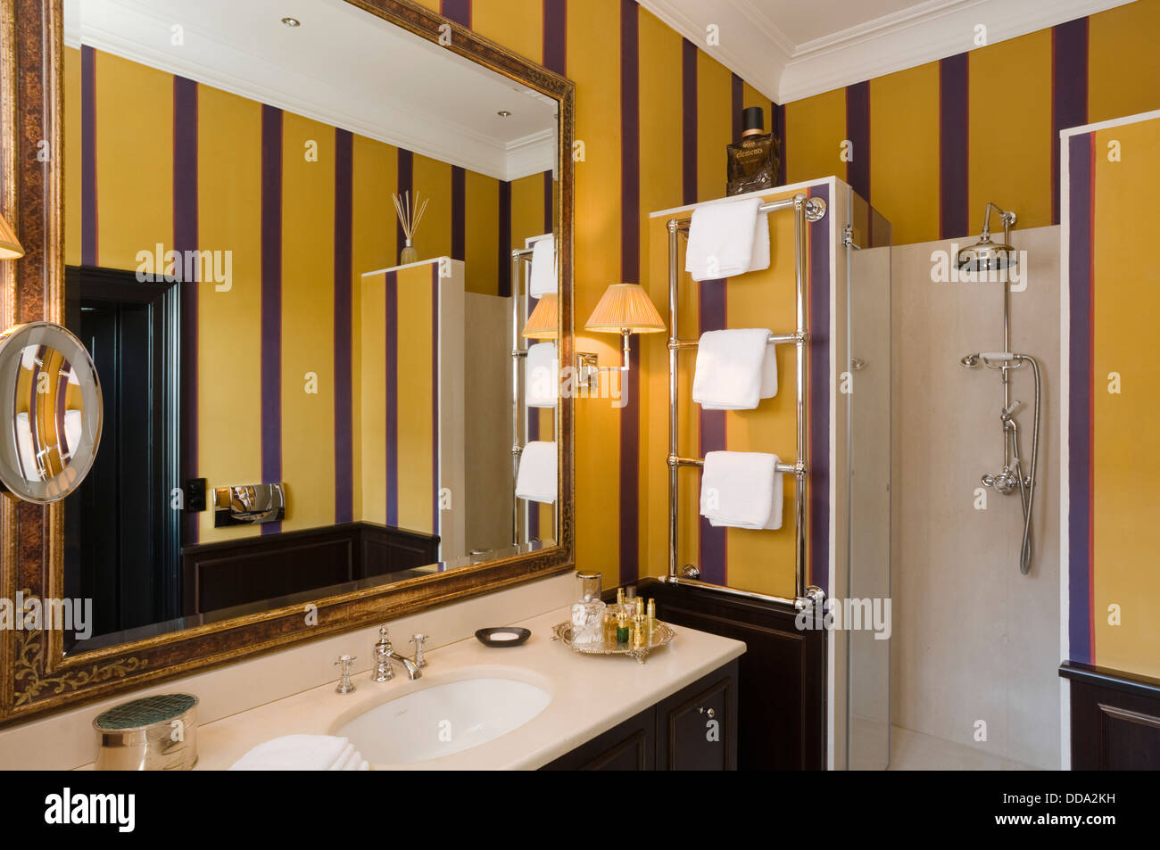 Gentleman's en suite bathroom with shower and wallpapered walls Stock Photo