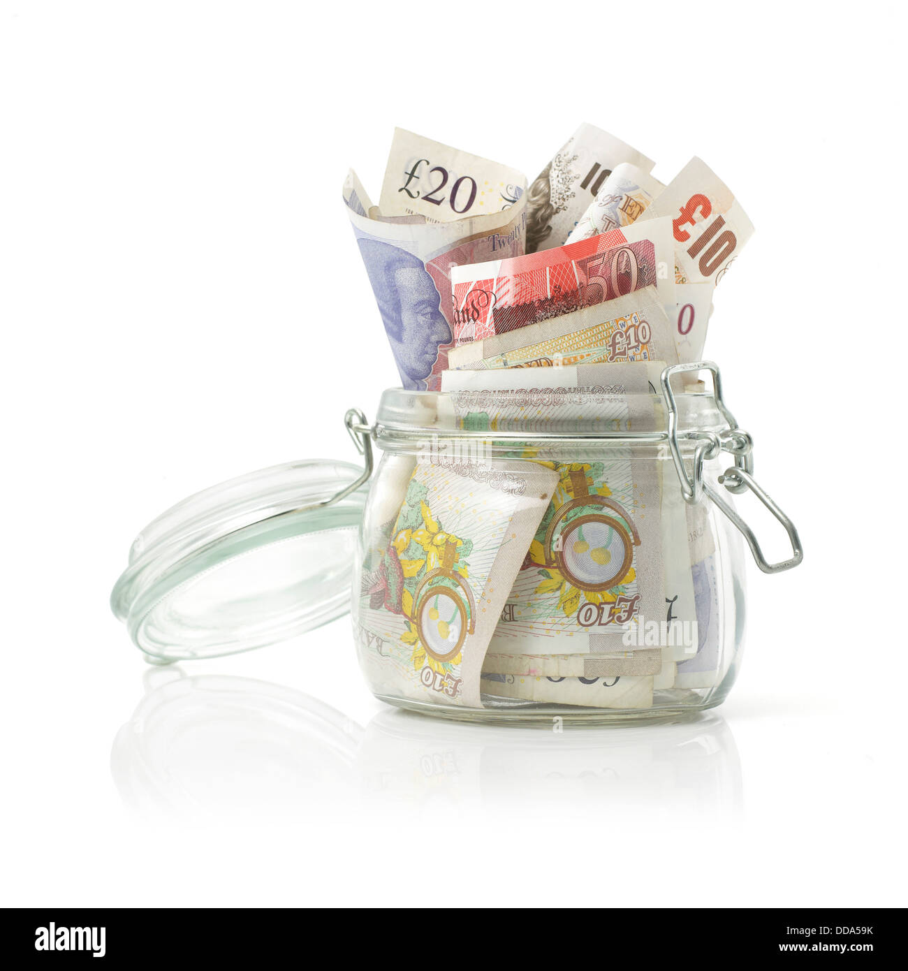 Variety of notes stuffed into glass jar on white background Stock Photo