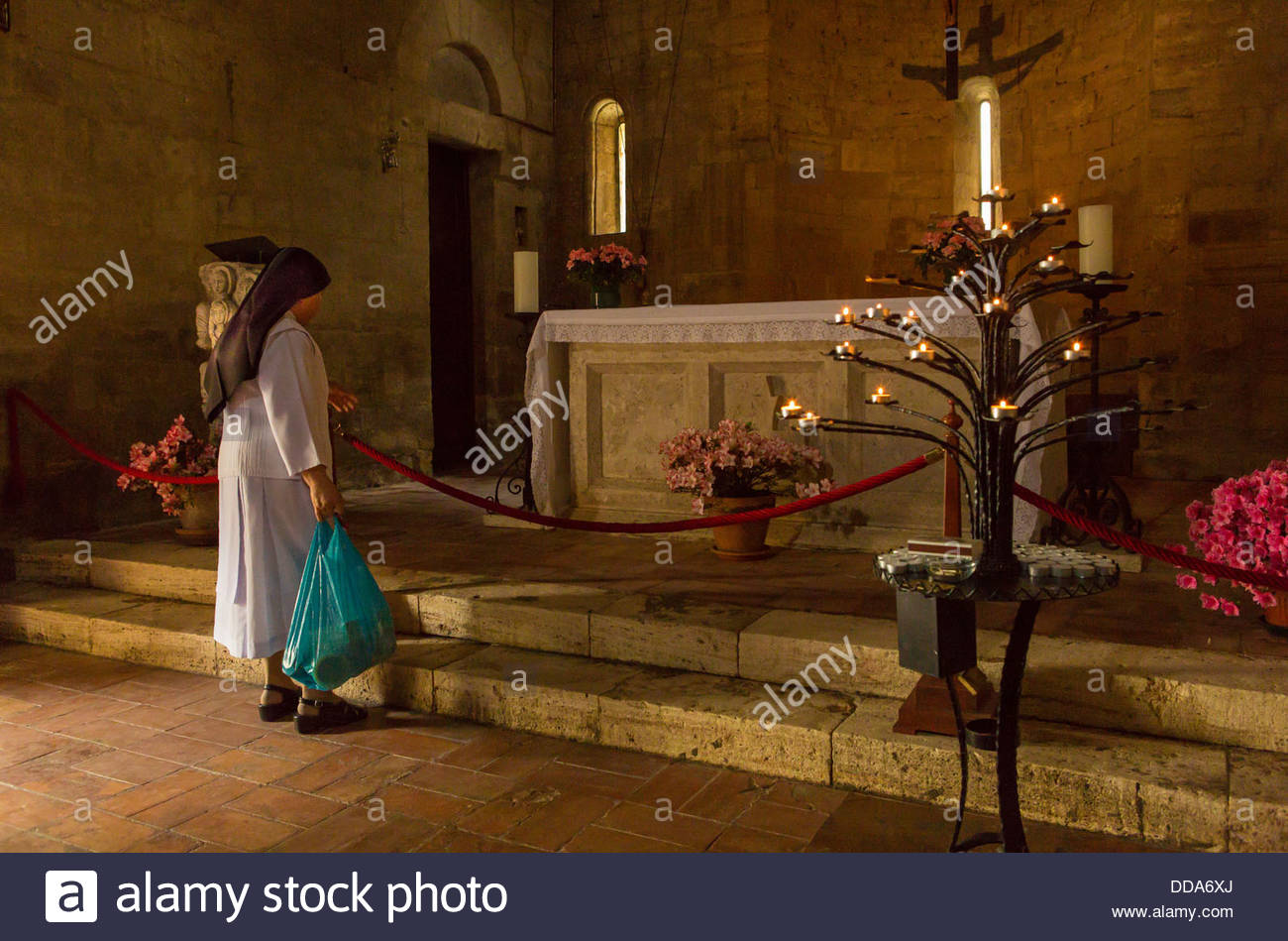 A nun pauses before the altar at the Chapel of Santa Maria Stock Photo