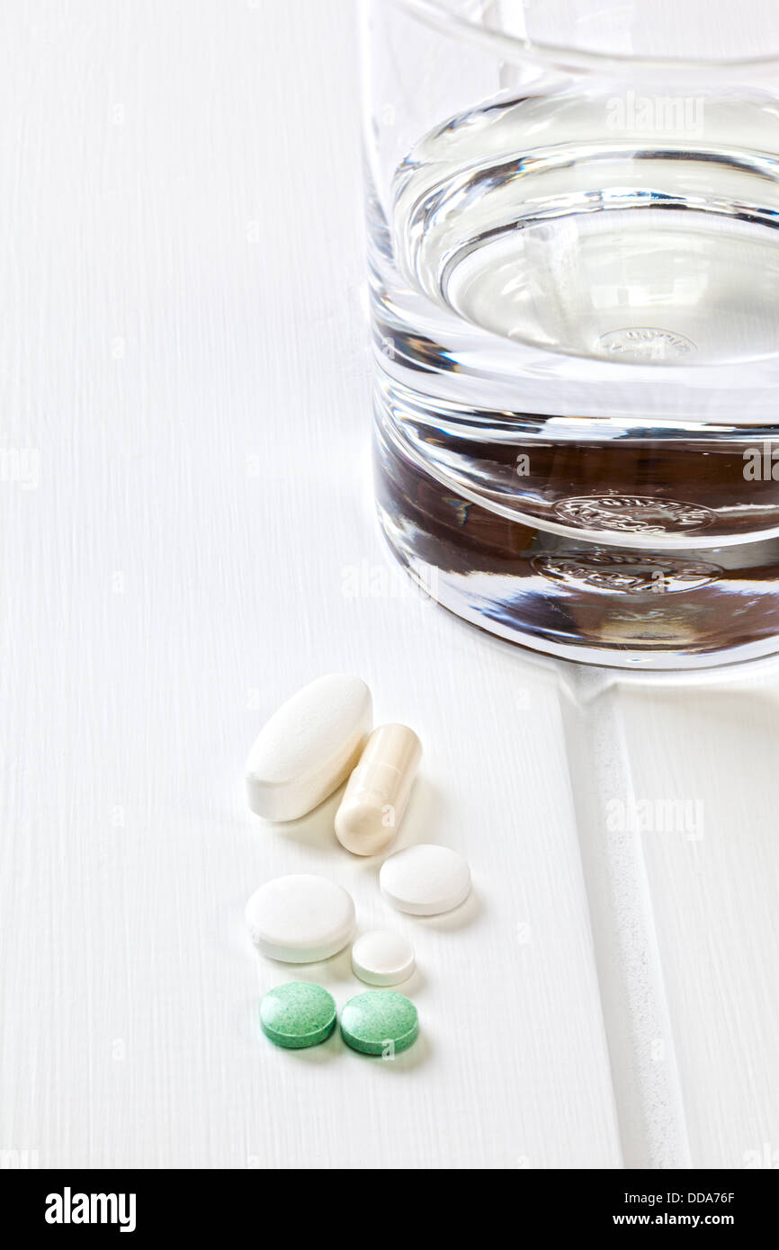 Tablets and a Glass of Water - various tablets with a glass of water. Stock Photo