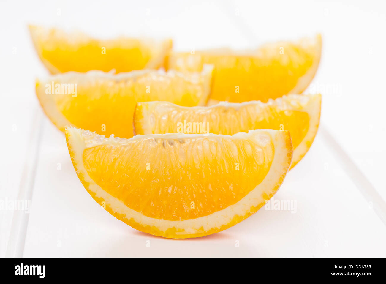 Orange Wedges on White Background - orange wedges or slices on a white background with soft shadows. Stock Photo