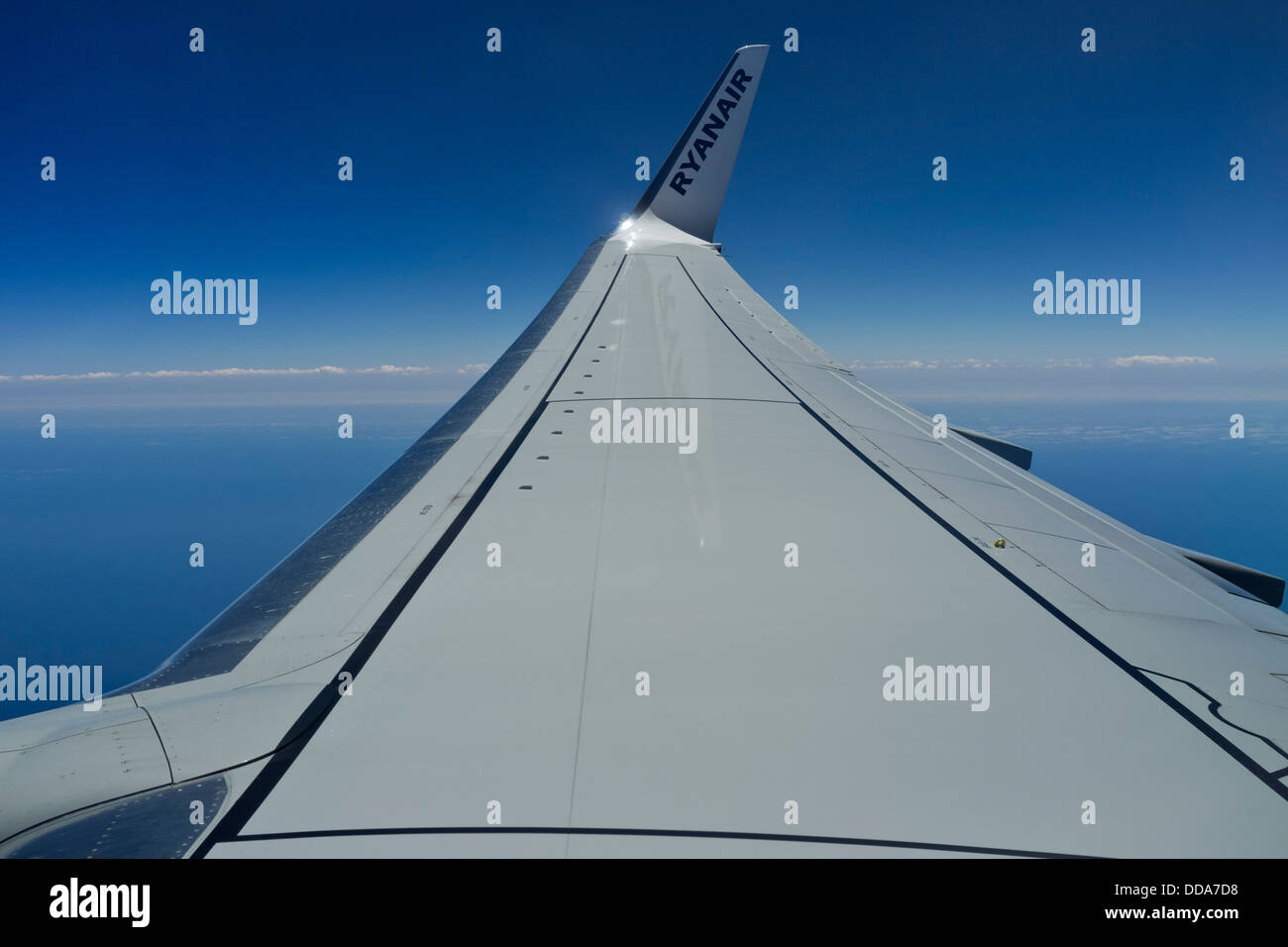 Wing of a ryanair airbus 320 seen against a deep blue sky. Stock Photo