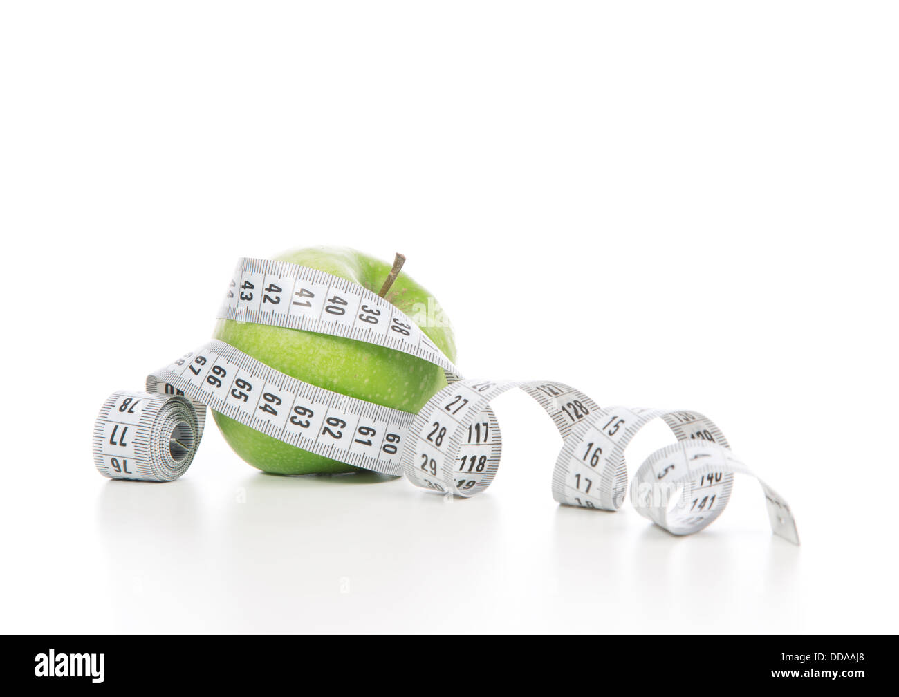 Healthy diet weight loss concept green apple and tape measure on a white background Stock Photo