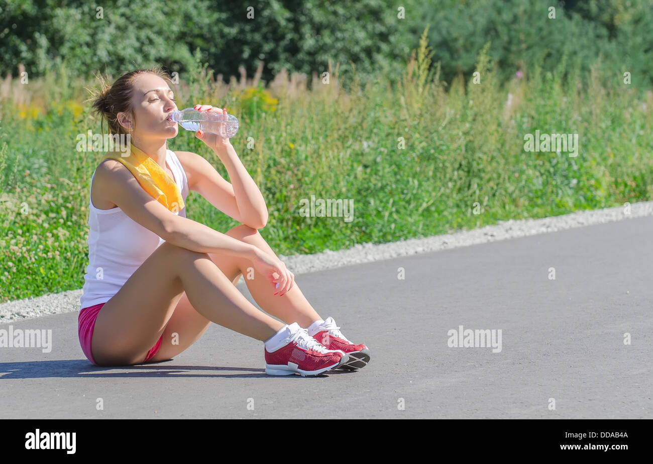 Sporty young female drinking water after workout Stock Photo - Alamy