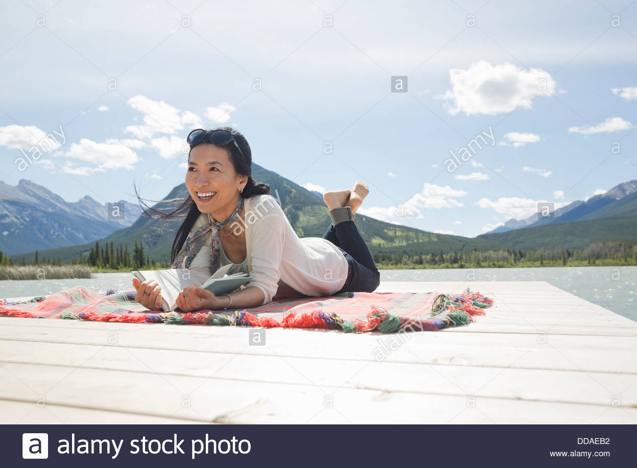 Mature woman reading on dock Stock Photo