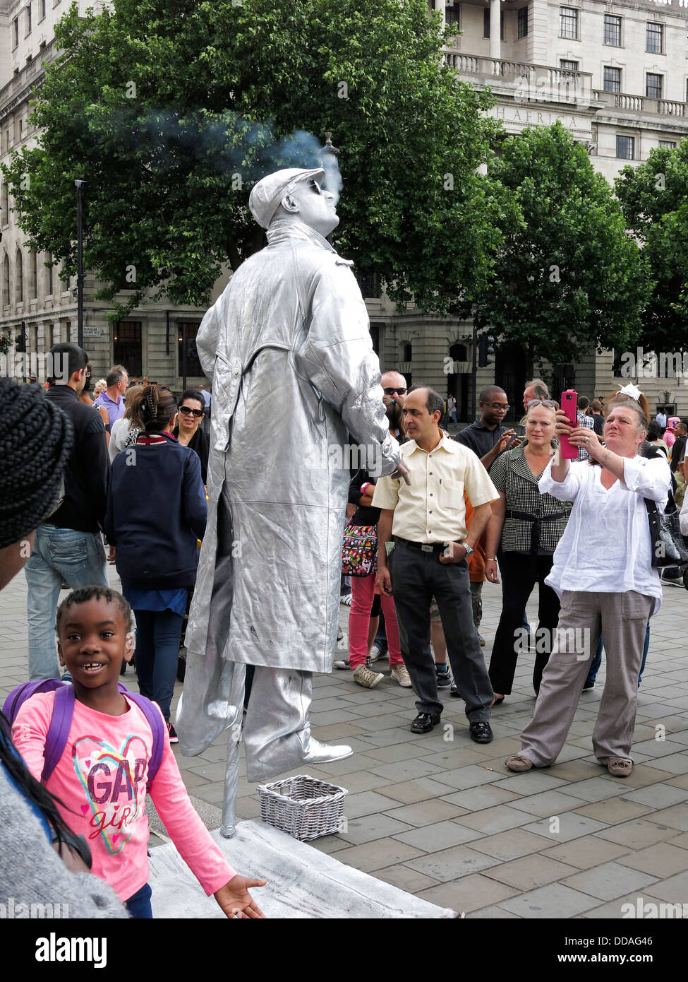Street performer busker dressed in silver and seemingly suspended in
