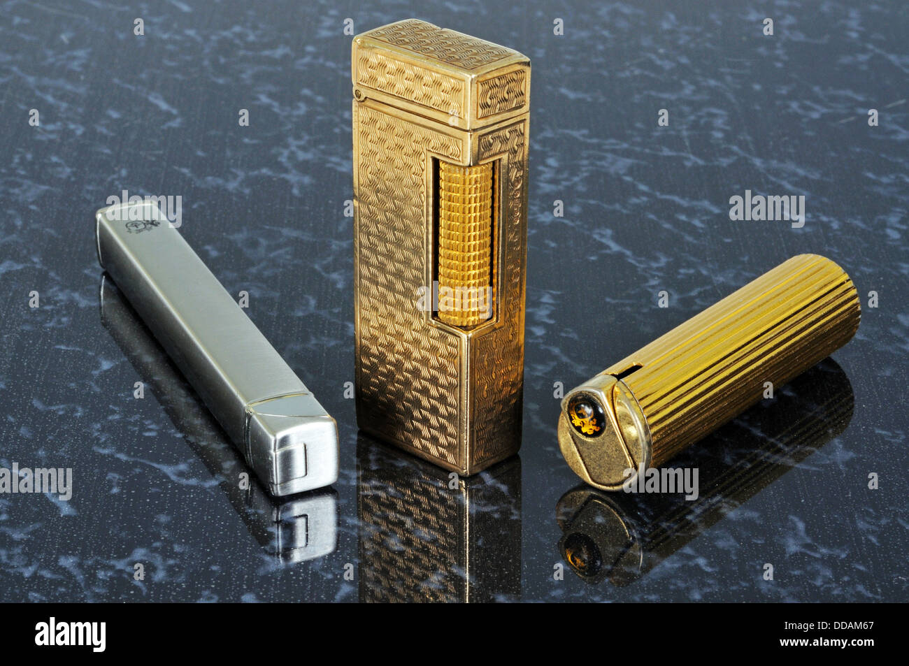 Chrome Colibri, Dunhill gold, and Colibri cigarette lighters. Stock Photo