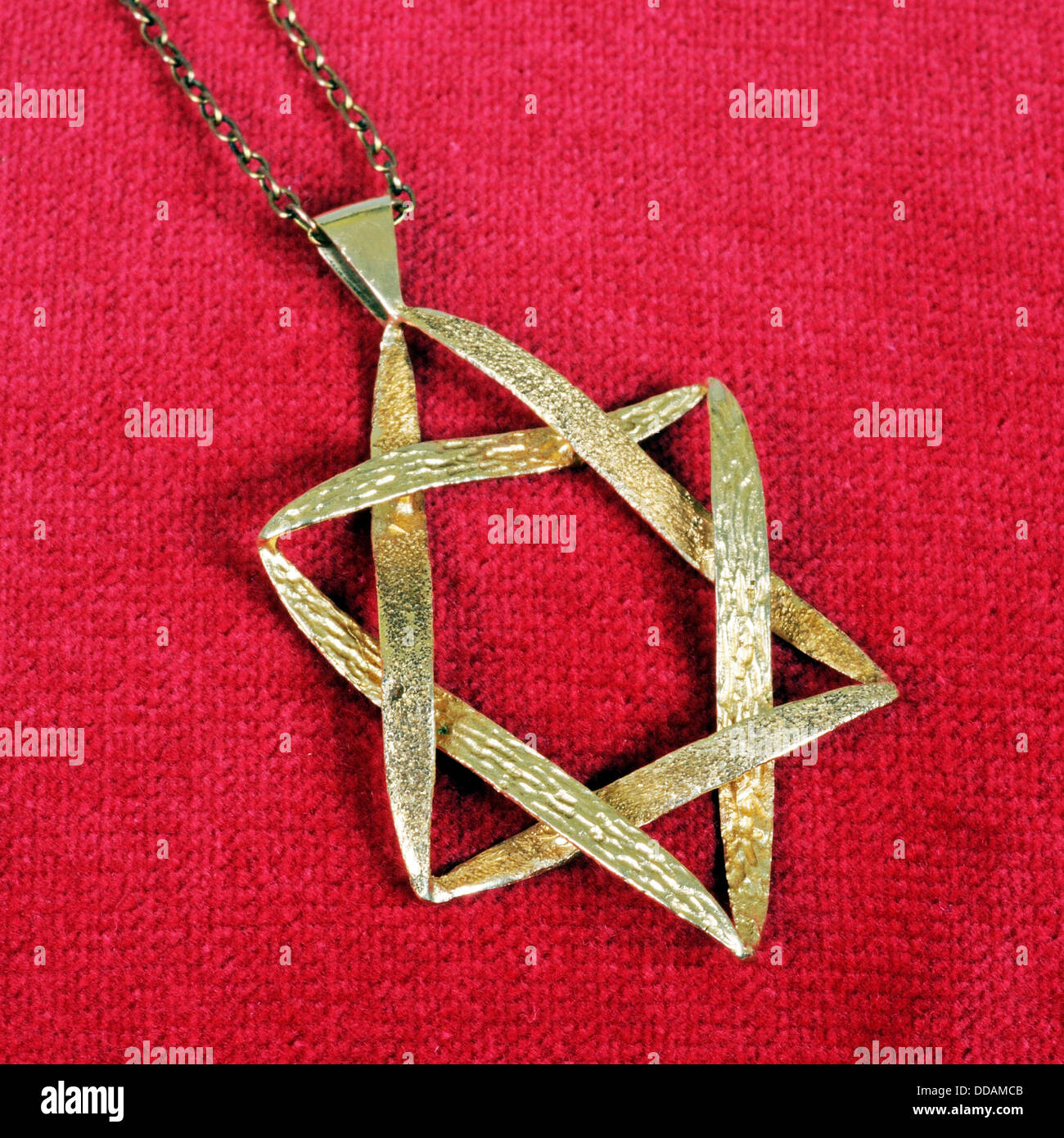 Star of David pendant against a red background. Stock Photo