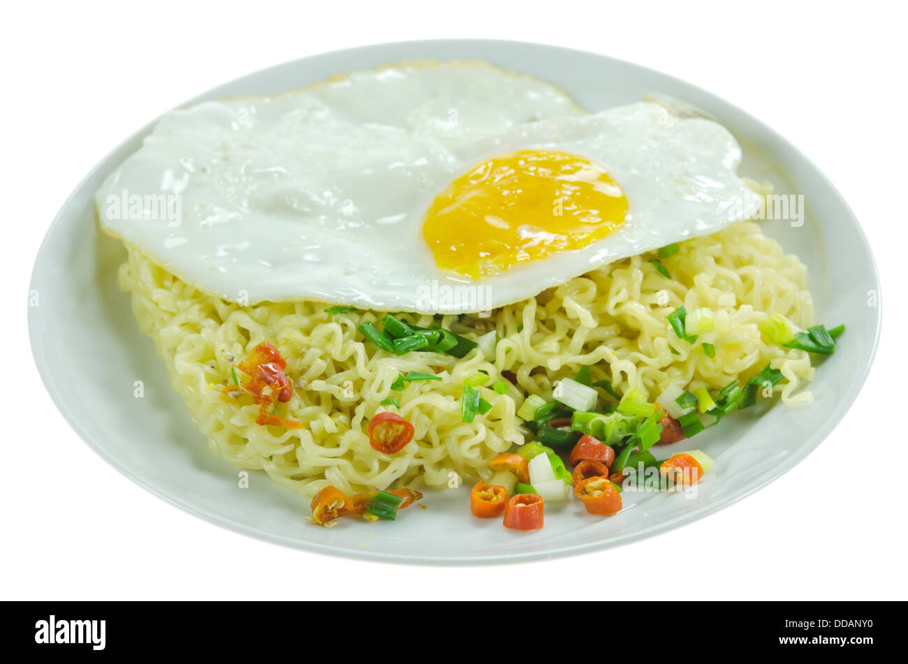 cooked instant noodles with chili and vegetable and fried egg on dish