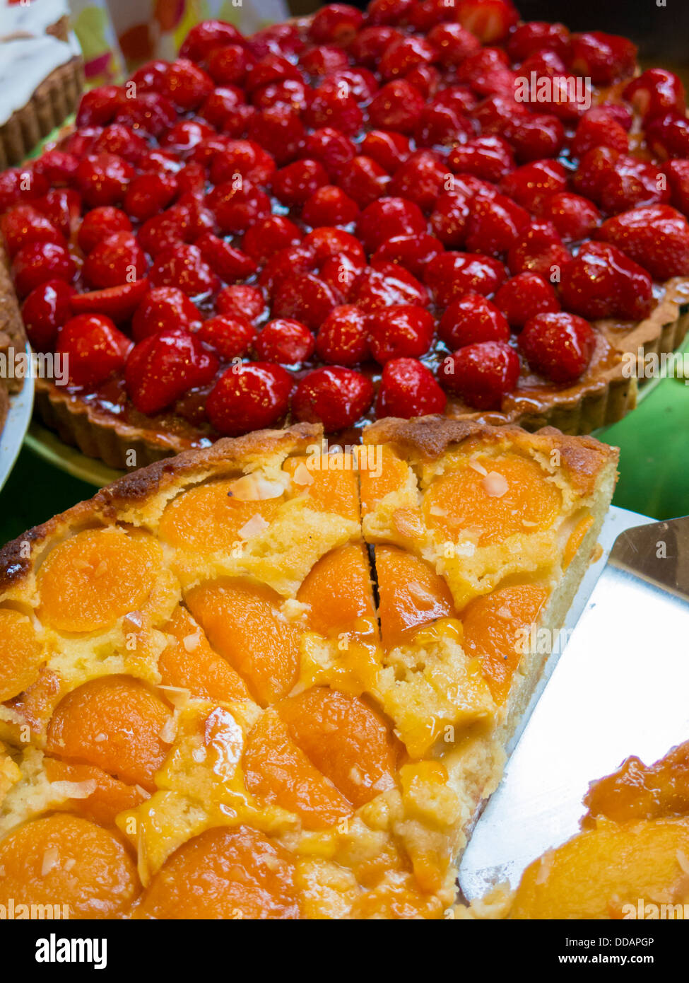 Peach flan in foreground with Strawberry flan in background on display ...
