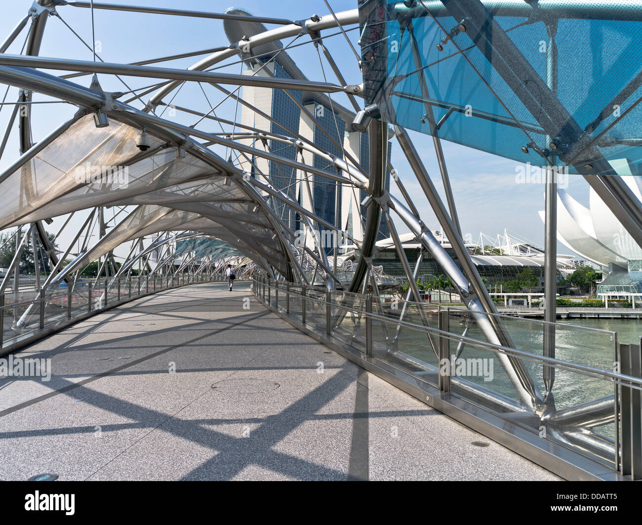 dh Helix bridge MARINA BAY SINGAPORE Man walking Marina Bay Sands Hotel modern architectural features Stock Photo