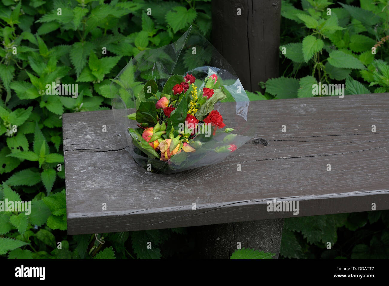 A small bouquet of  flowers left on a bench in memoriam England uk Stock Photo