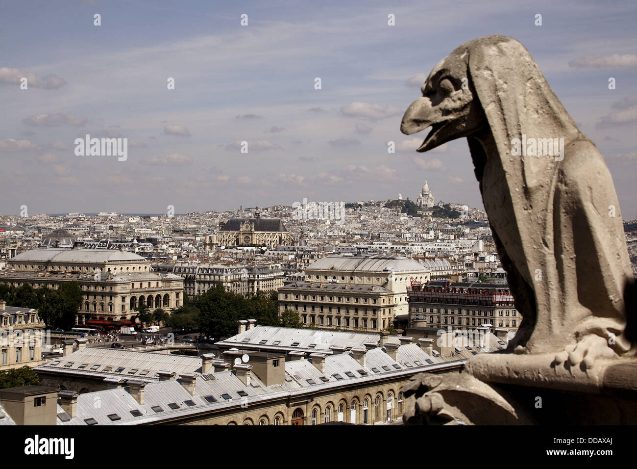 France. Paris. A gargoyle on the Galerie des Chimeres of Notre - Dame Cathedral with the view of city of Paris and Sacre - Stock Photo