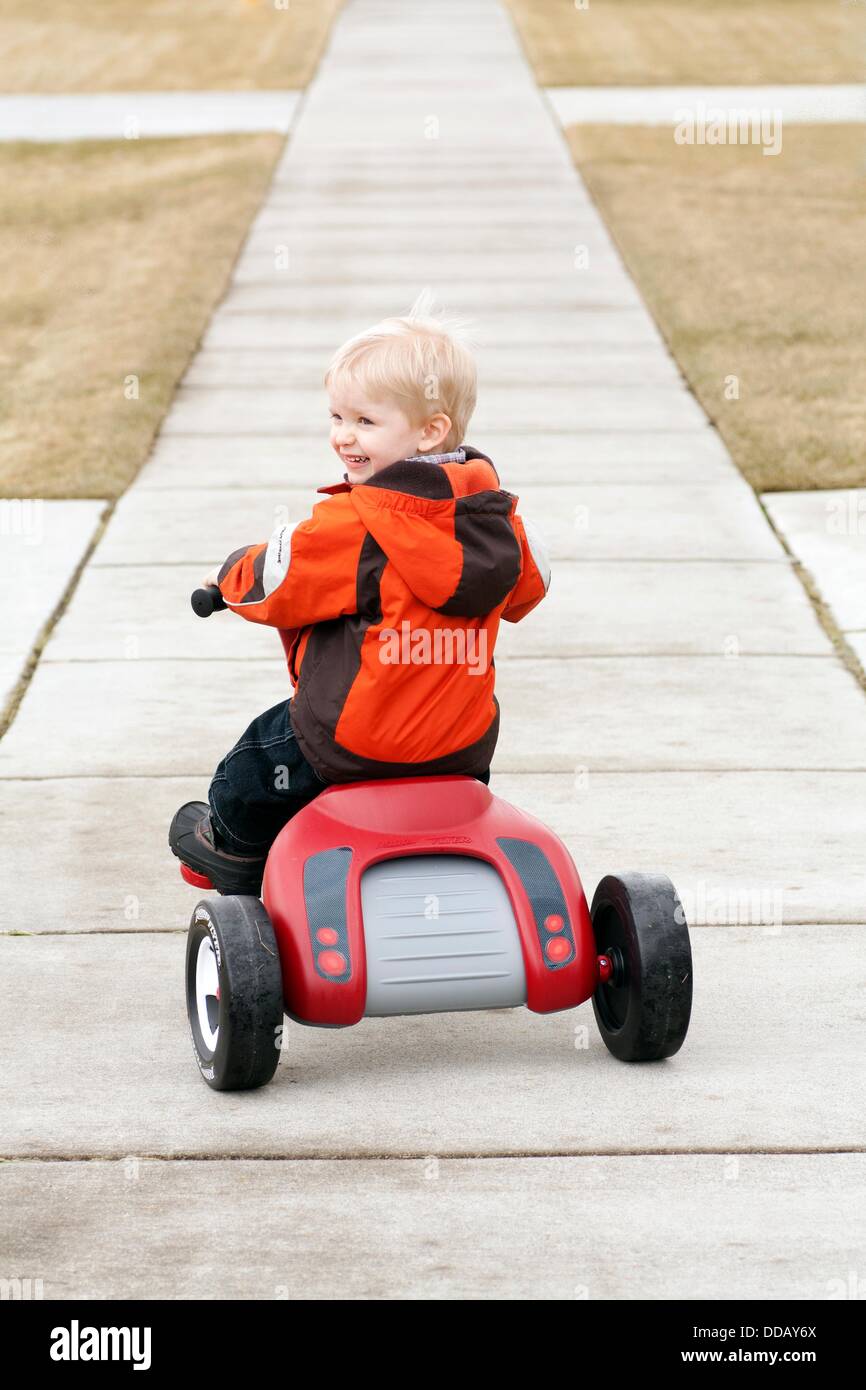 A threeyearold boy playing on a tricycle Stock Photo Alamy