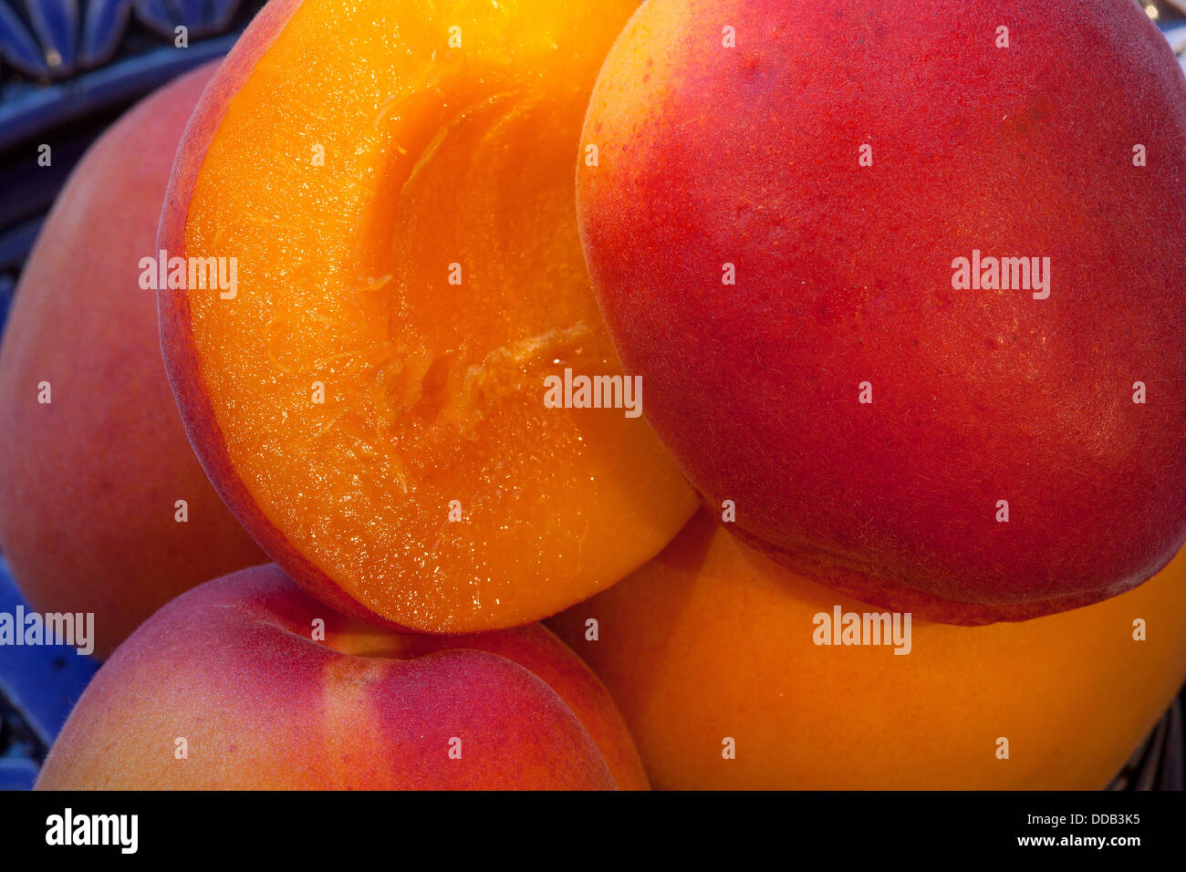ripe apricot halves in a blue bowl Stock Photo