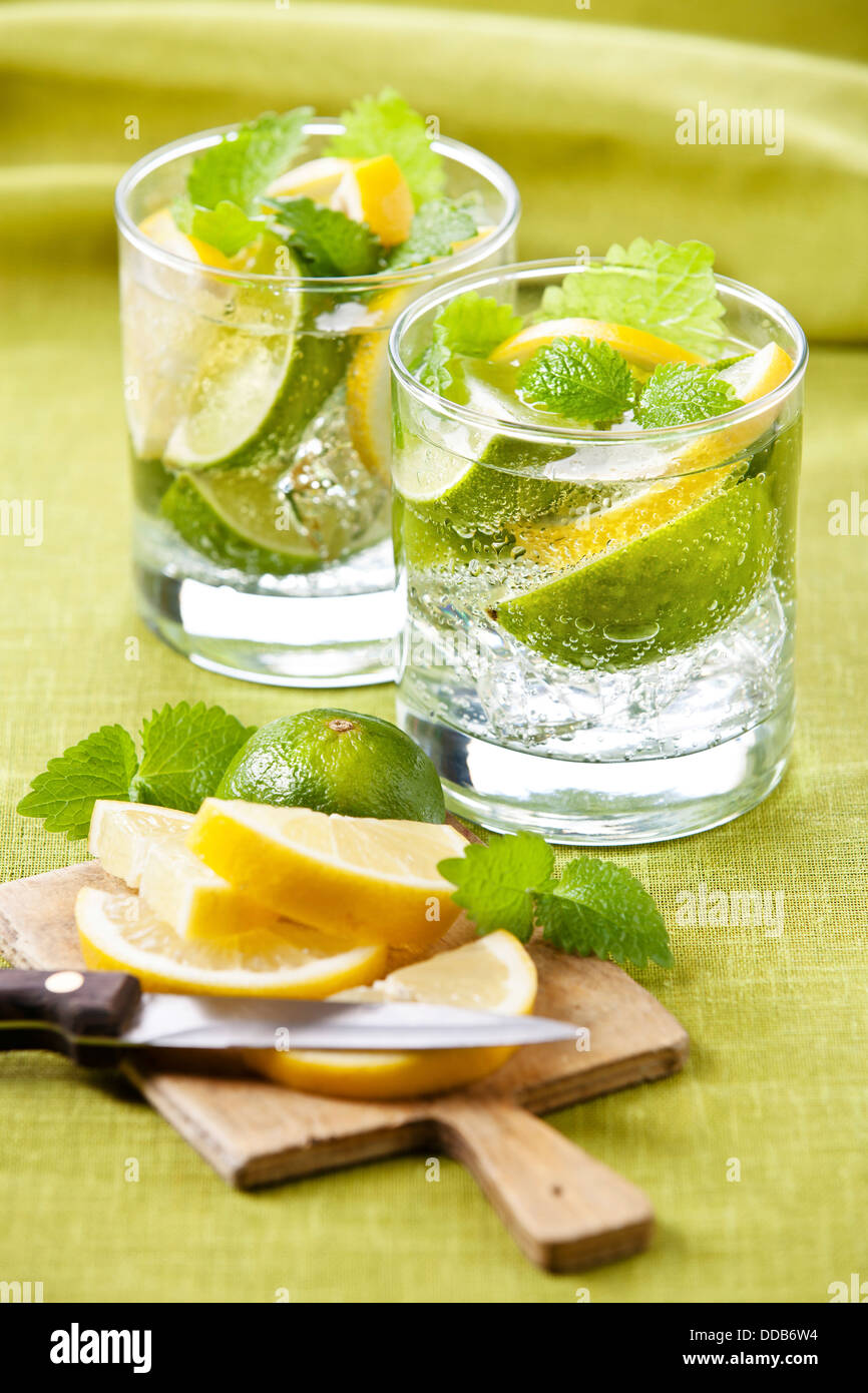 Cold fresh lemonade with lemon and lime on green background Stock Photo