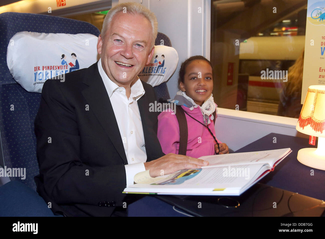 Deutsche Bahn railway company chairman Ruediger Grube reads a book to pupils from the St. Ursula elementary school in an ICE train from Berlin to Hamburg, Germany, 30 August 2013. On the occasion of the 10th nationwide Reading Day on 15 November, celebraties read stories from the book 'Komm, ich lese dir vor!'. Photo: MALTE CHRISTIANS Stock Photo