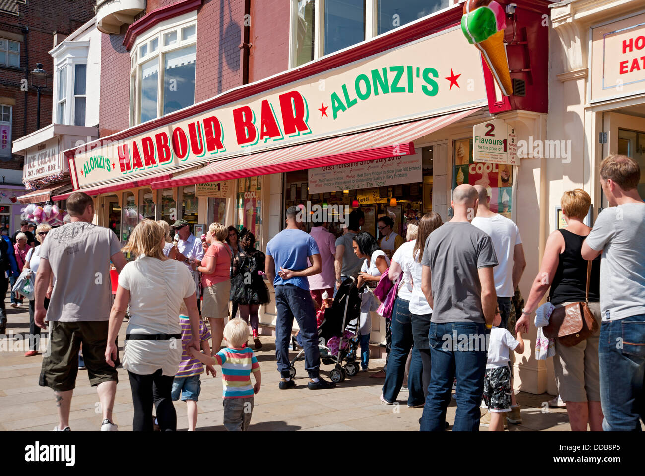 People tourists visitors walking by Harbour Bar cafe in summer Scarborough seafront resort North Yorkshire England UK United Kingdom GB Great Britain Stock Photo