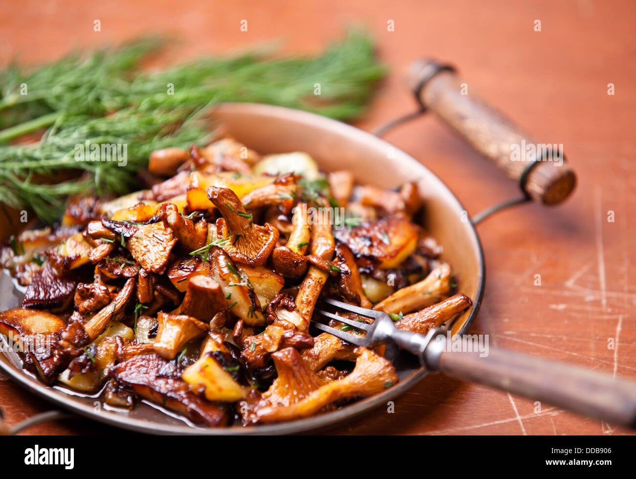 Fried chanterelles with potatoes and onion in batch pan on the table Stock Photo