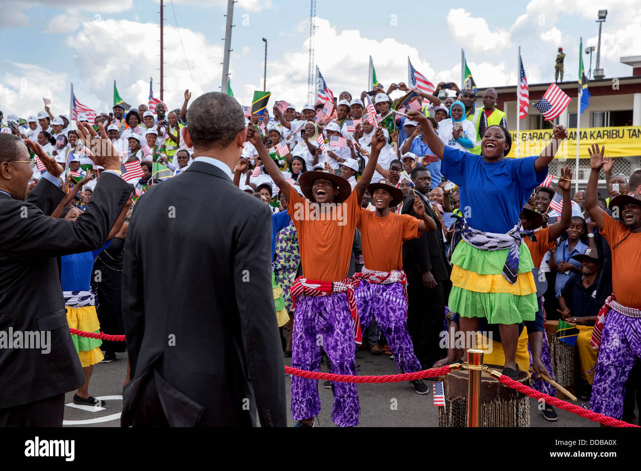 US President Barack Obama watches performers on the tarmac before departing Julius Nyerre International Airport July 2, 2013 in Dar es Salaam, Tanzania. Tanzanian President Jakaya Kikwete waves at left. Stock Photo