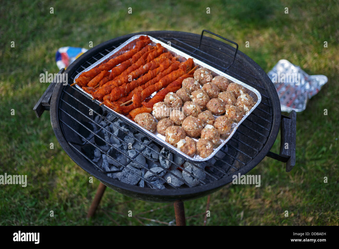 Emden, Germany, on a charcoal grill in a foil dish are meat and Hackbaellchen torches Stock Photo
