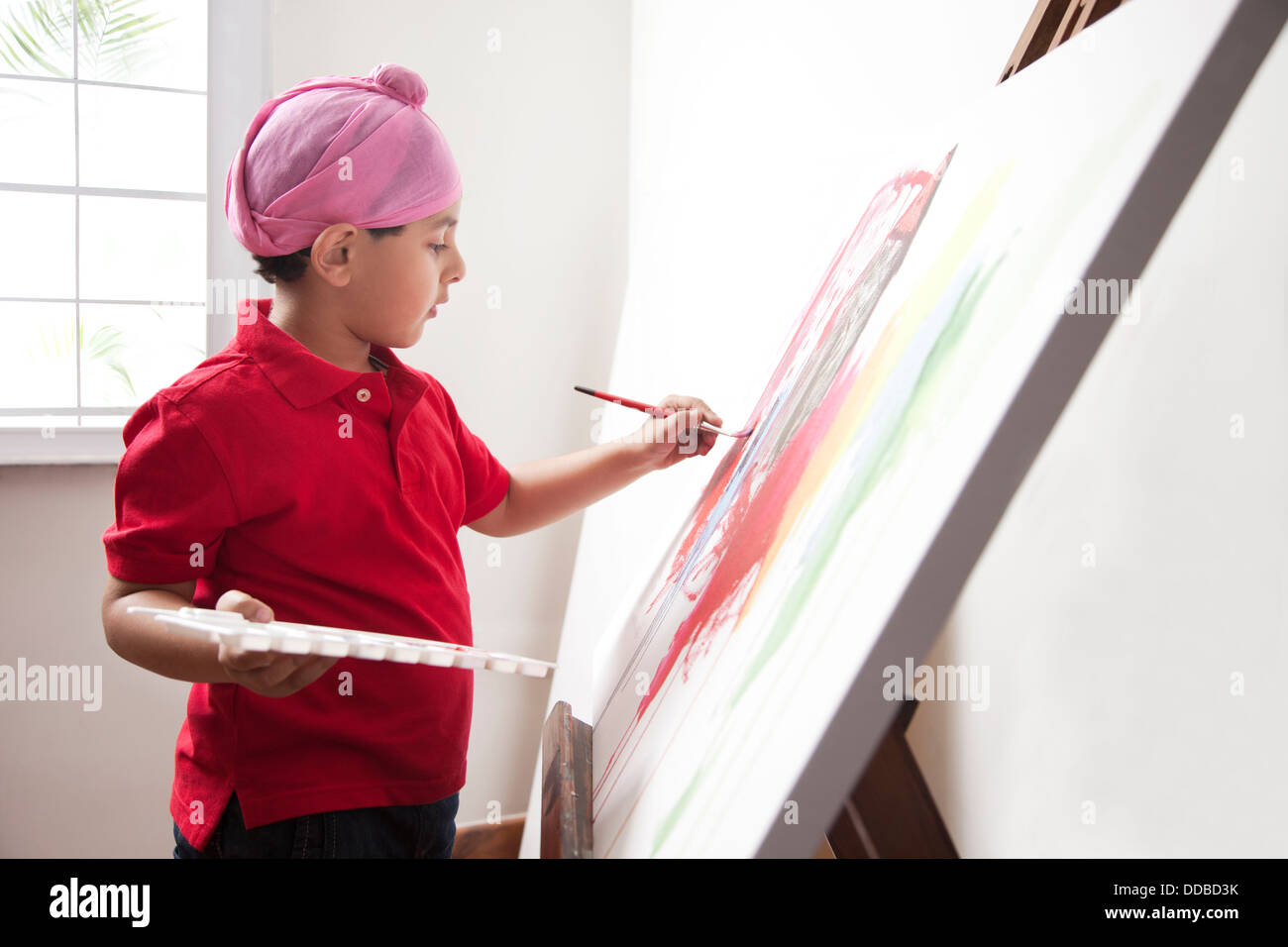 Cute little boy painting on artist's canvas with paintbrush Stock Photo ...