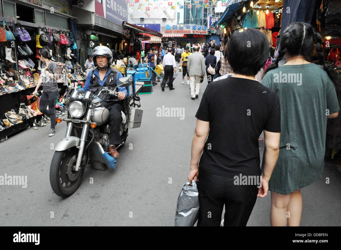 Seoul (South Korea) a man driving a motorbike in a alley at the