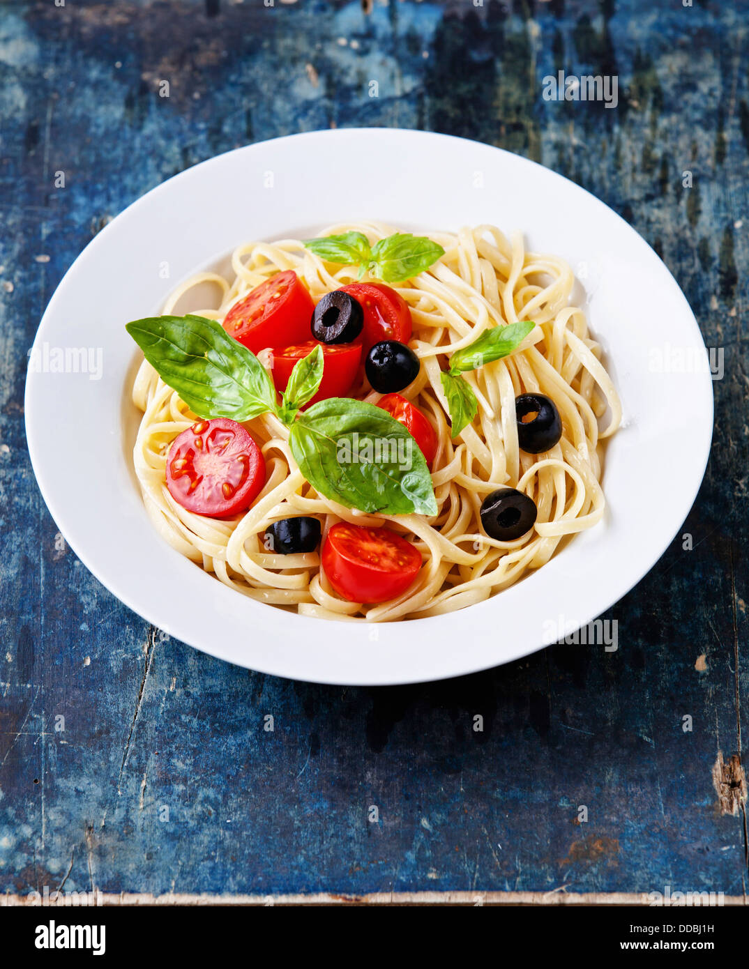 Pasta with tomato and basil on blue wooden background Stock Photo
