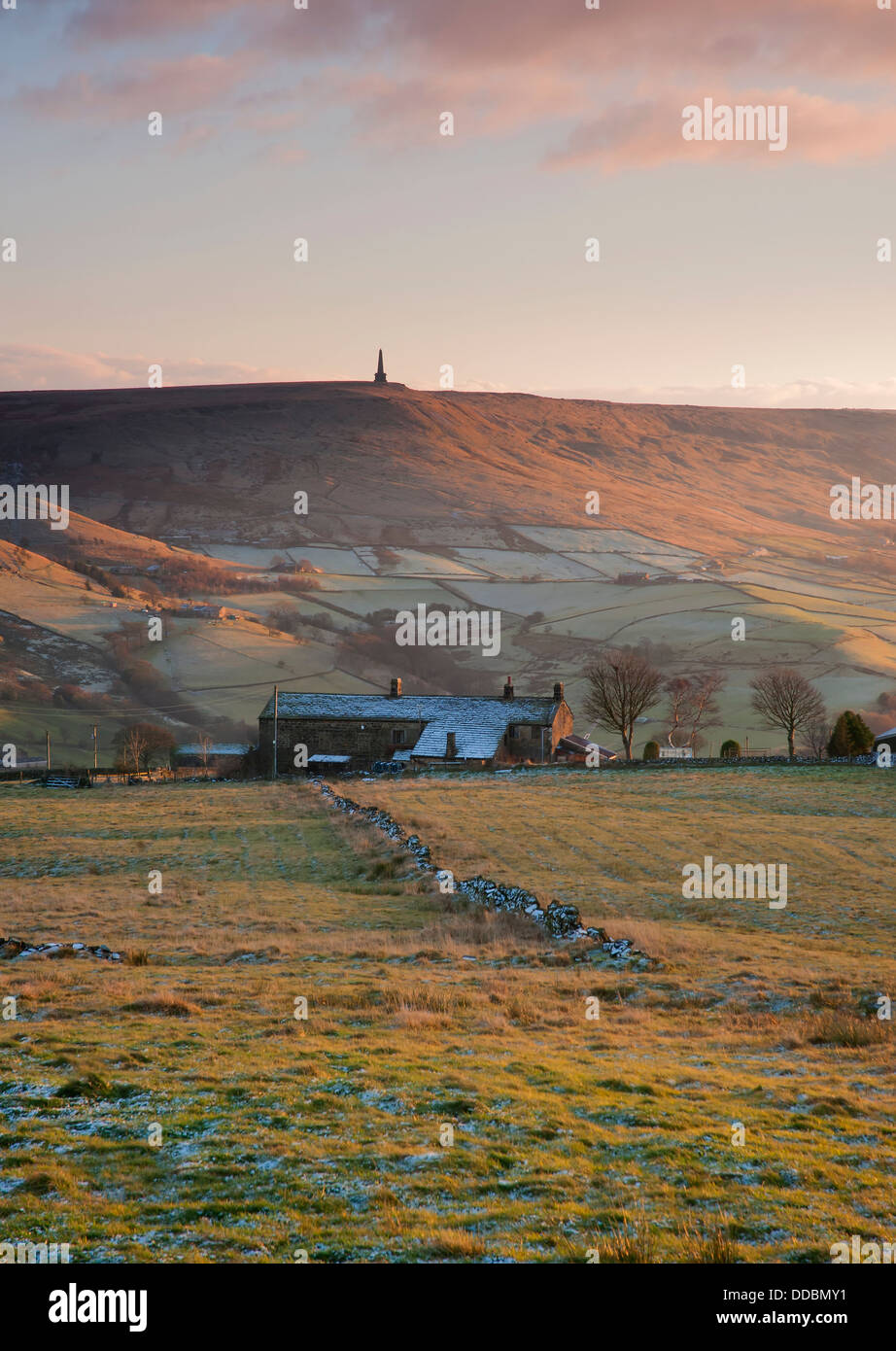 frosty winters day on yorkshire moorland with side lit moorland farmhouse and hillside. Stock Photo