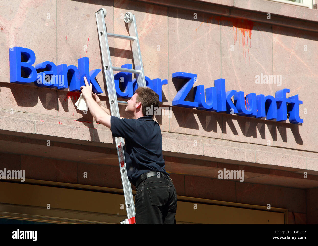 Berlin, Germany, man cleans the logo of Deutsche Bank Stock Photo
