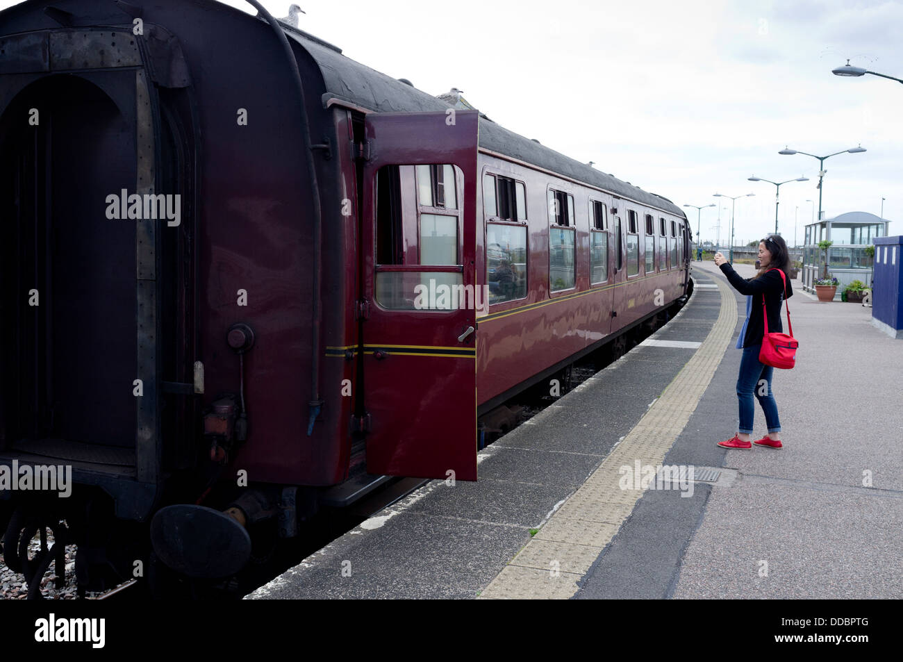A Tourist Taking A Picture Of The Jacobite Steam Train At Mallaig