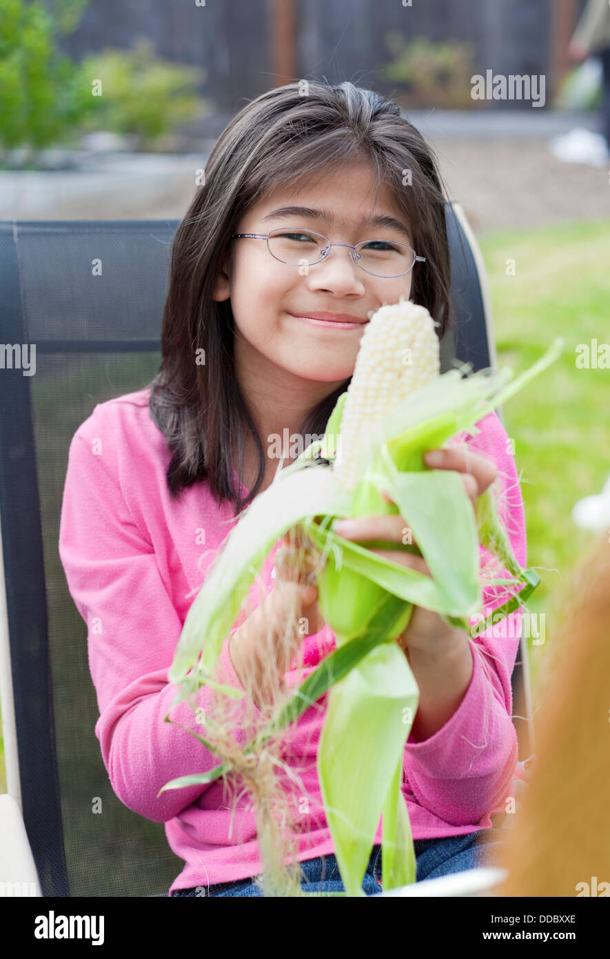 Girl peeling husk off corn cob Stock Photo Alamy