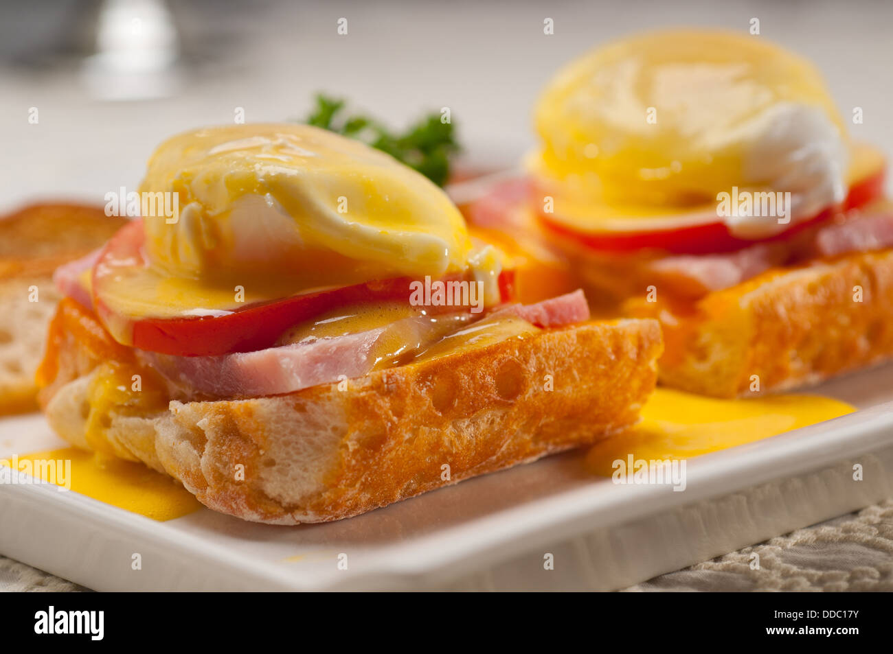 eggs benedict on bread with tomato and ham Stock Photo Alamy