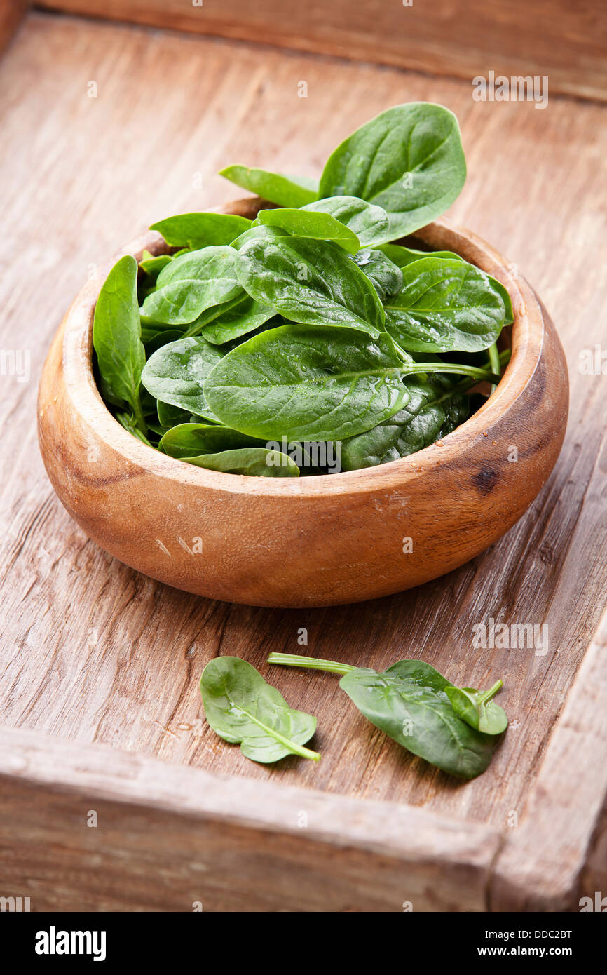 Young spinach in wooden bowl Stock Photo