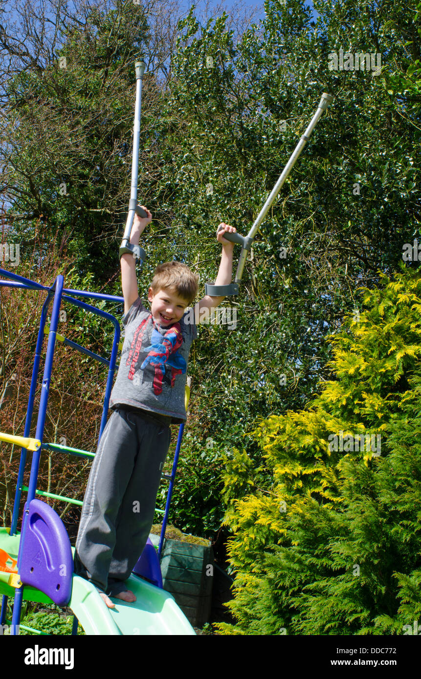 eight year old boy with crutches thinking about being adventurous on a