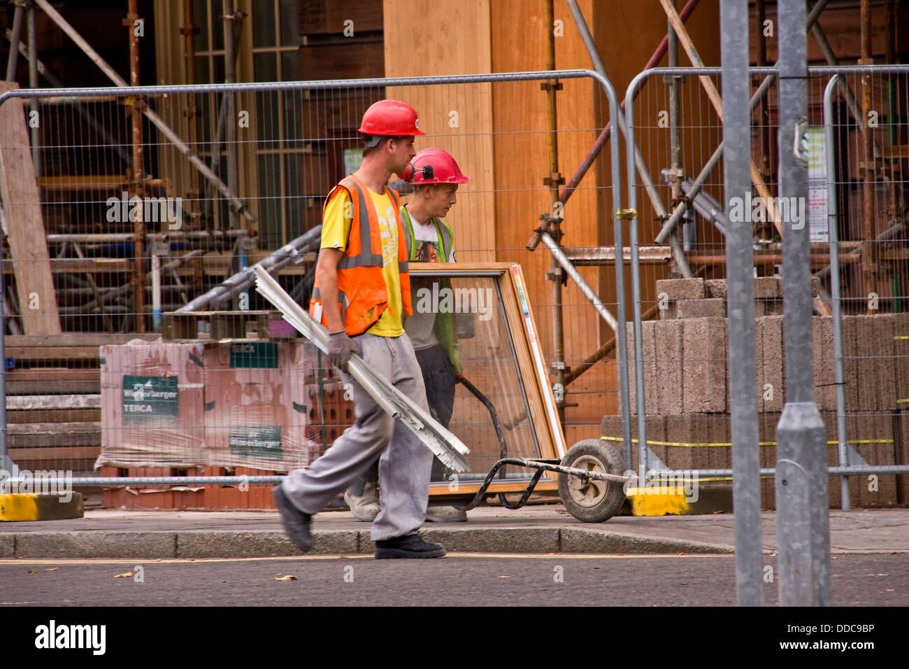 Two workmen carrying a large glass hires stock photography and images