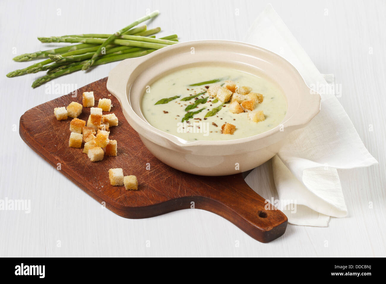 Asparagus soup cream with croutons on white wooden background Stock Photo