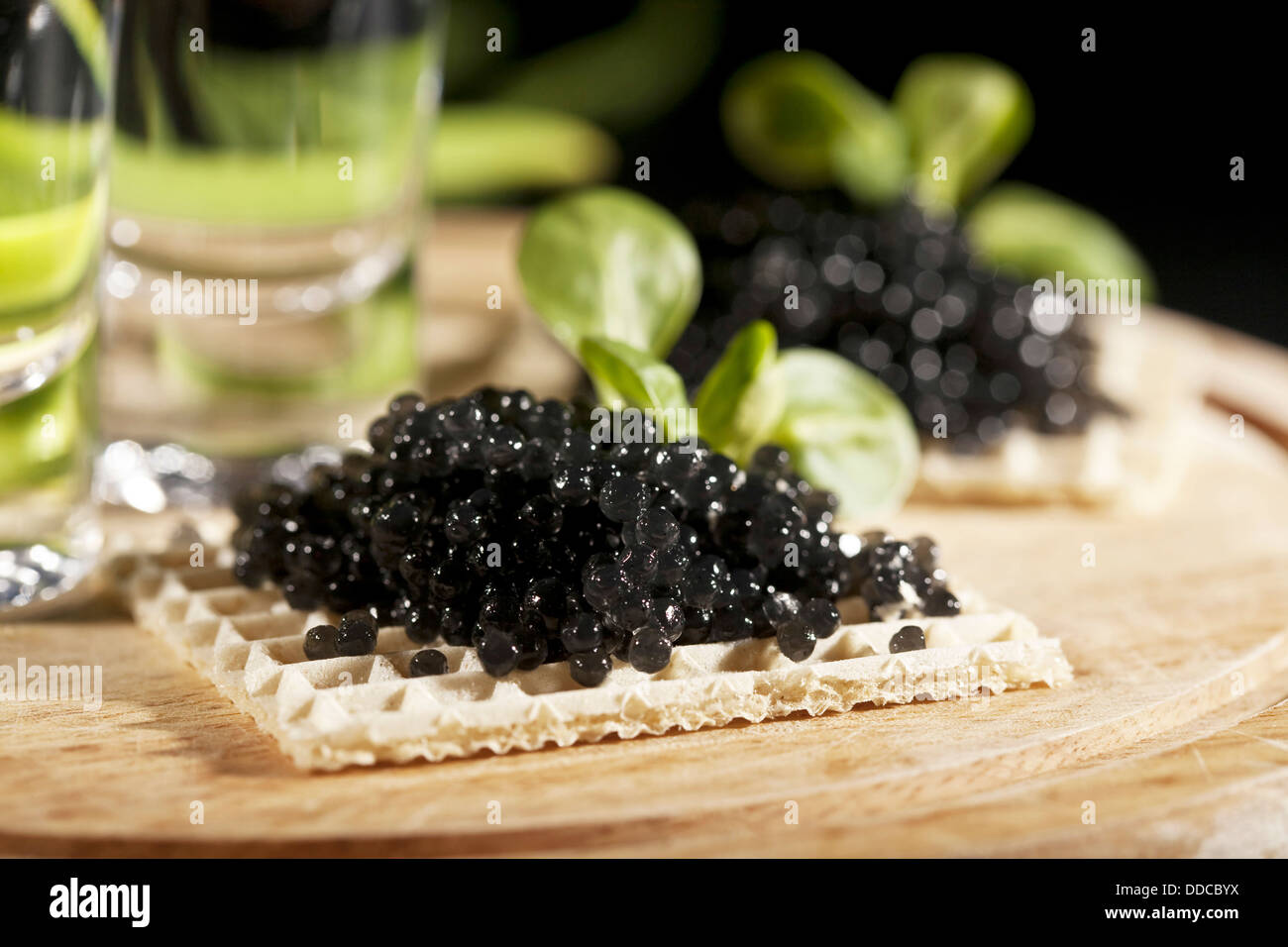 vodka and sandwiches with black caviar on black background Stock Photo