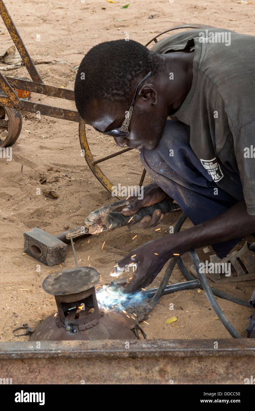 Welder Working in Blacksmith's Shop, Where Soil Rippers are Made, near Kaolack, Senegal. Stock Photo