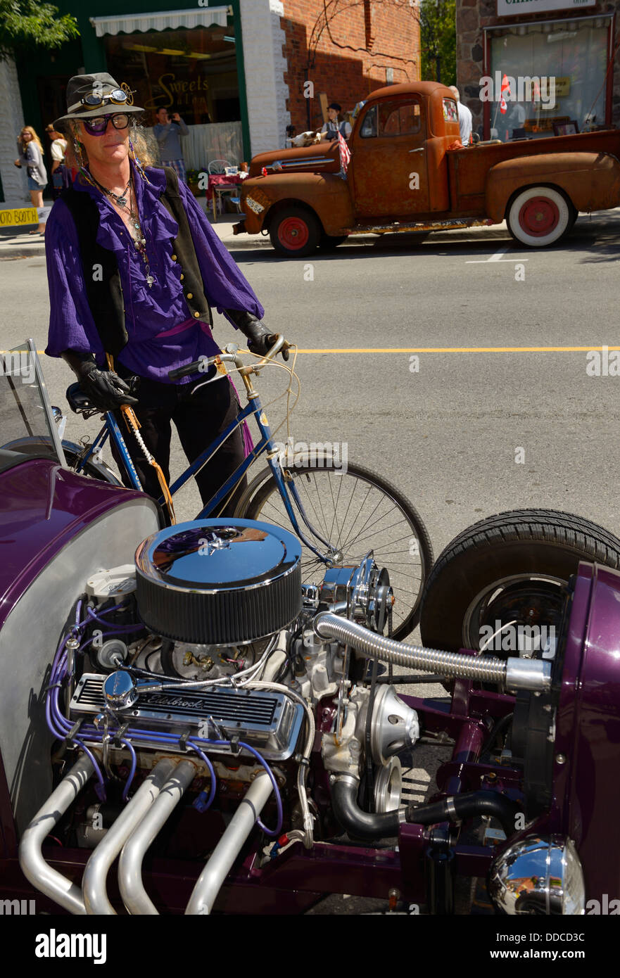 Coldwater purple steampunk participant with a hot rod and rusted Ford truck in background Stock Photo