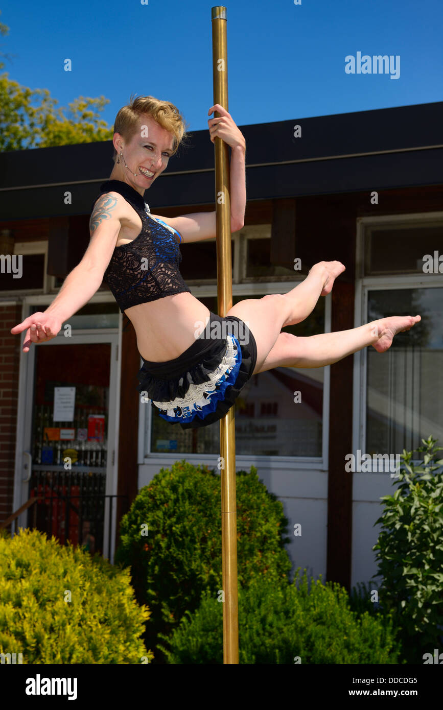 Pretty young woman with piercings and tattoo pole dancing at Steampunk festival in Coldwater Ontario Stock Photo