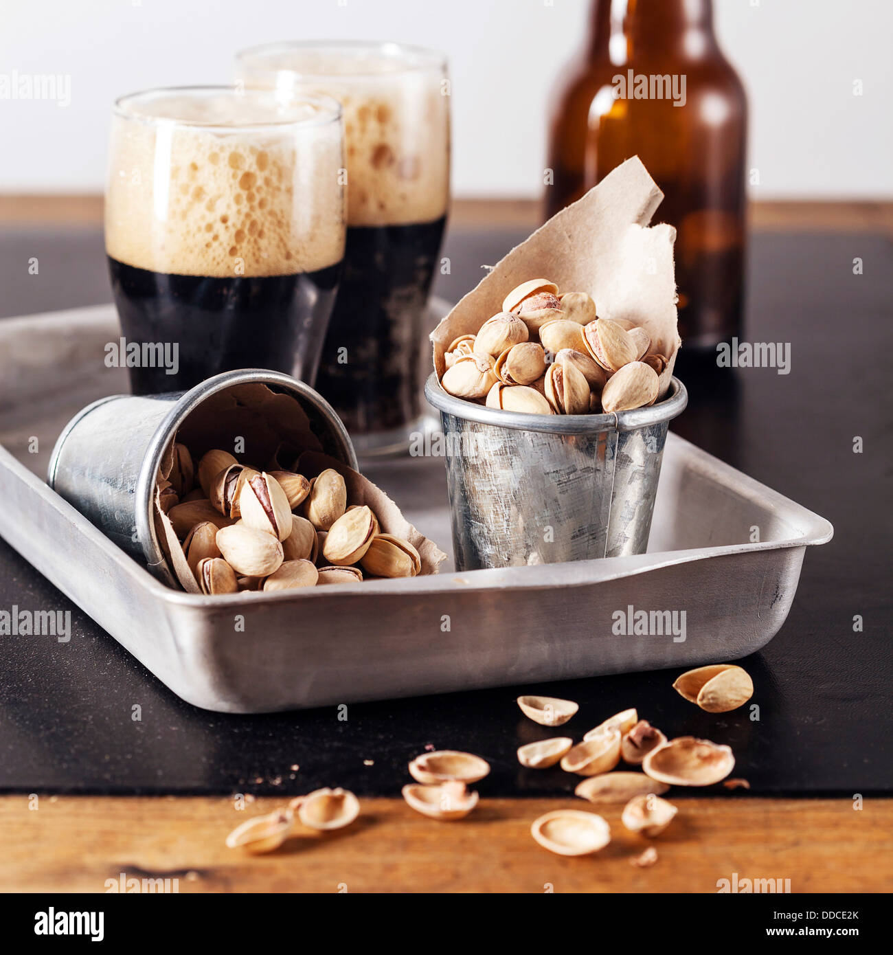 Dark beer and salted pistachios Stock Photo
