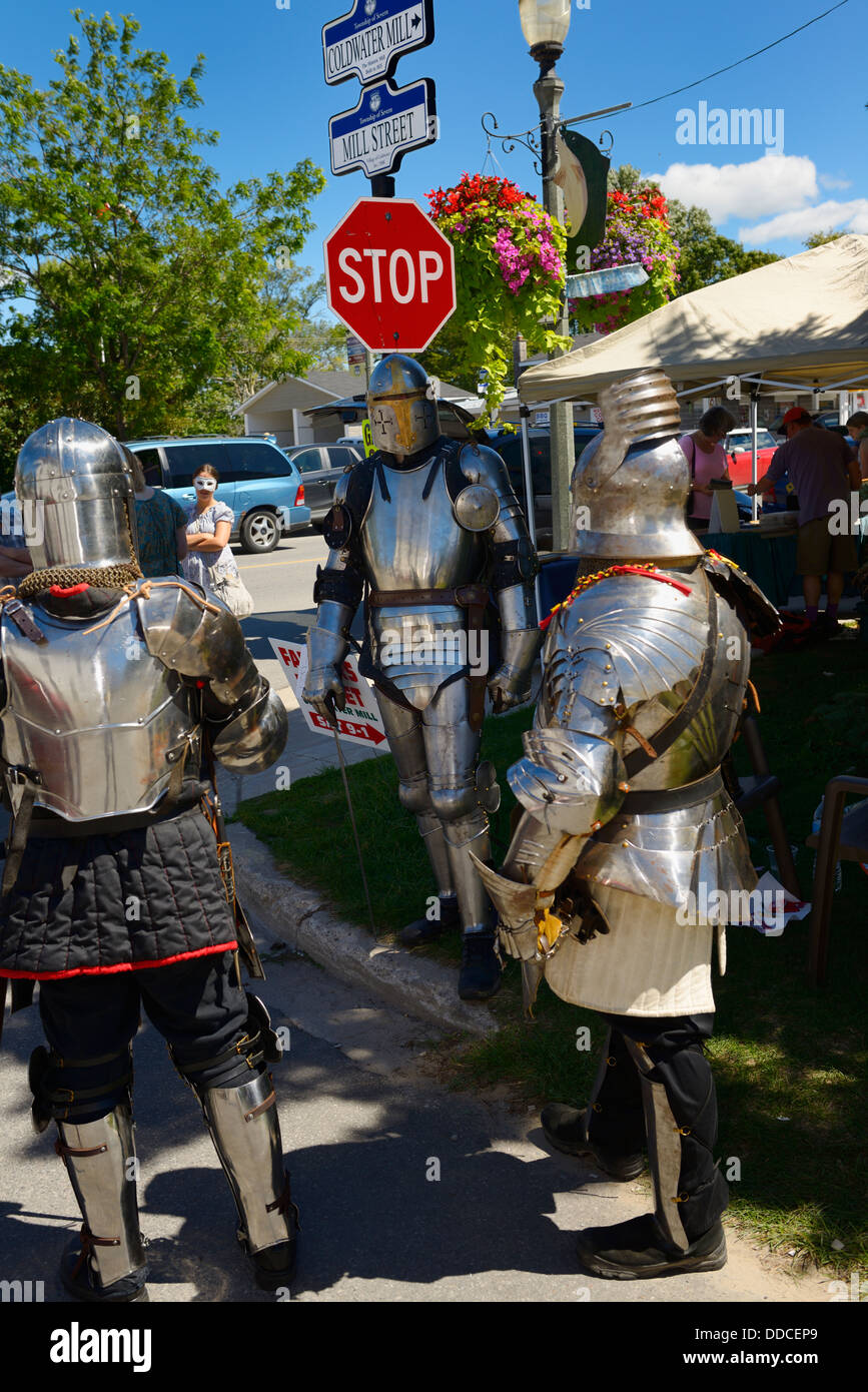 Stop sign in Coldwater Ontario during steampunk festival with three men in suits of armour Stock Photo