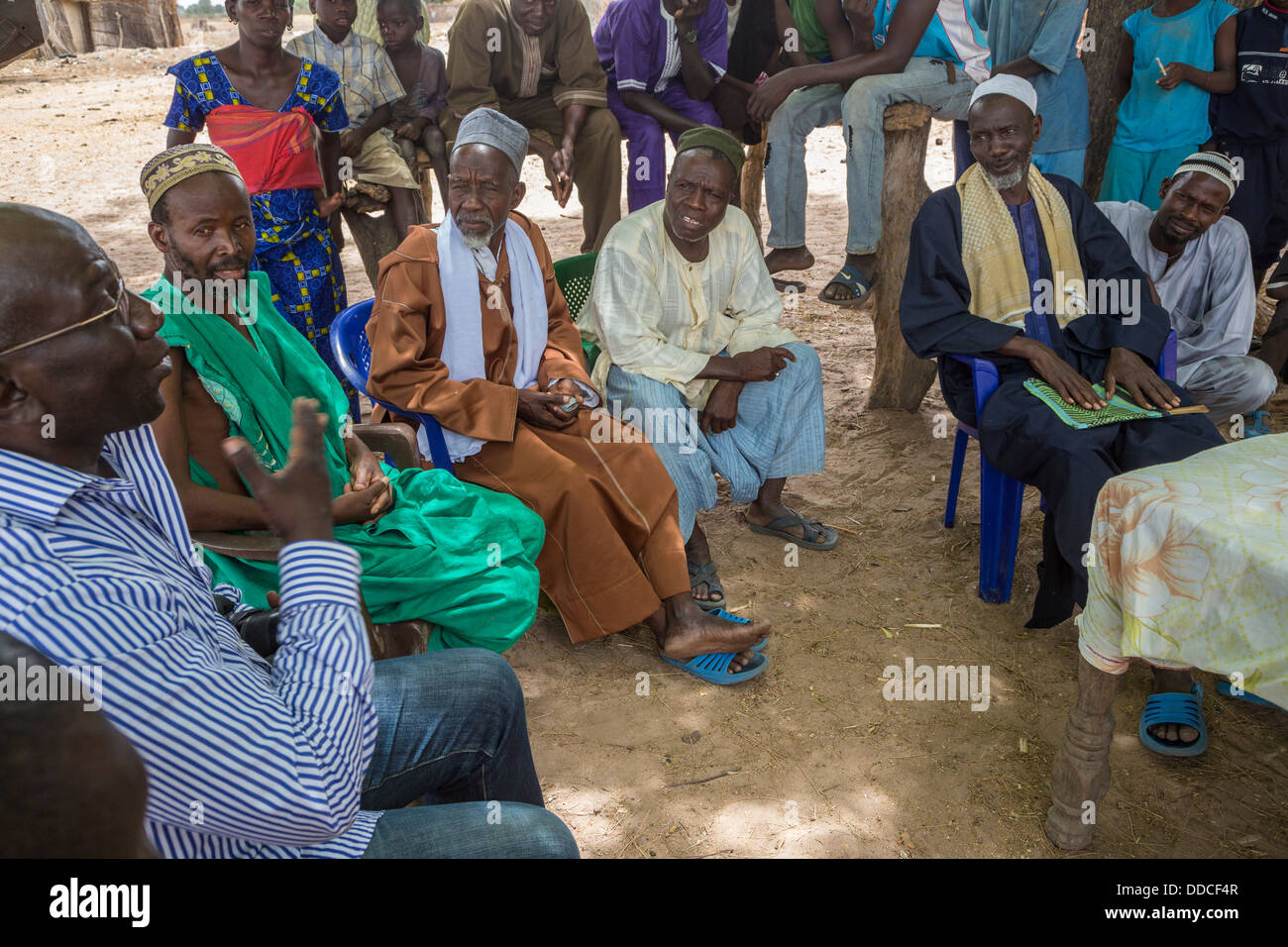 Manager of Non-profit NGO (western dress) Speaks to Men at Microcredit Meeting, Djilor, a Wolof Village, near Kaolack, Senegal. Stock Photo