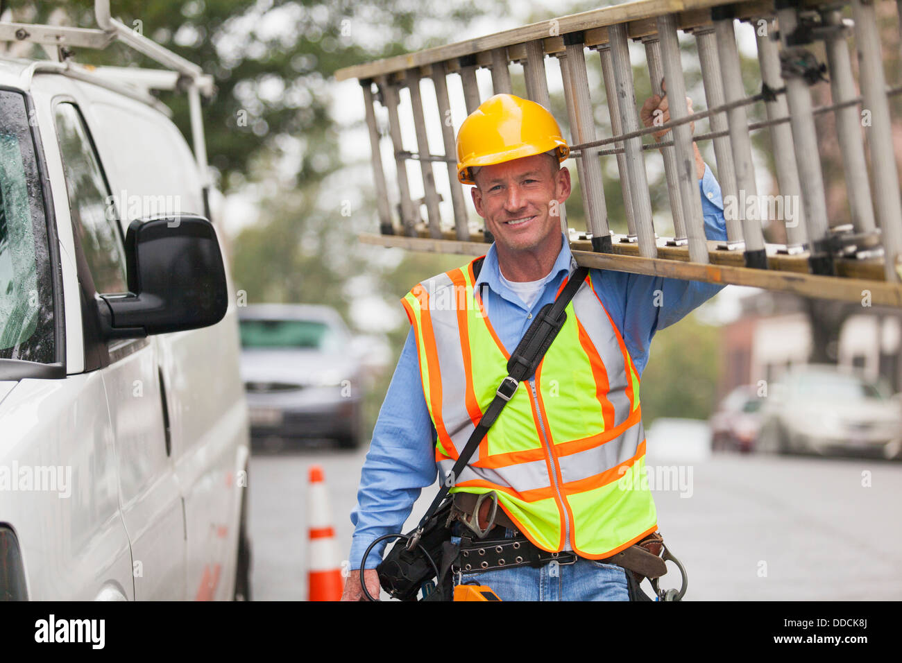 Cable lineman carrying ladder from service truck Stock Photo Alamy
