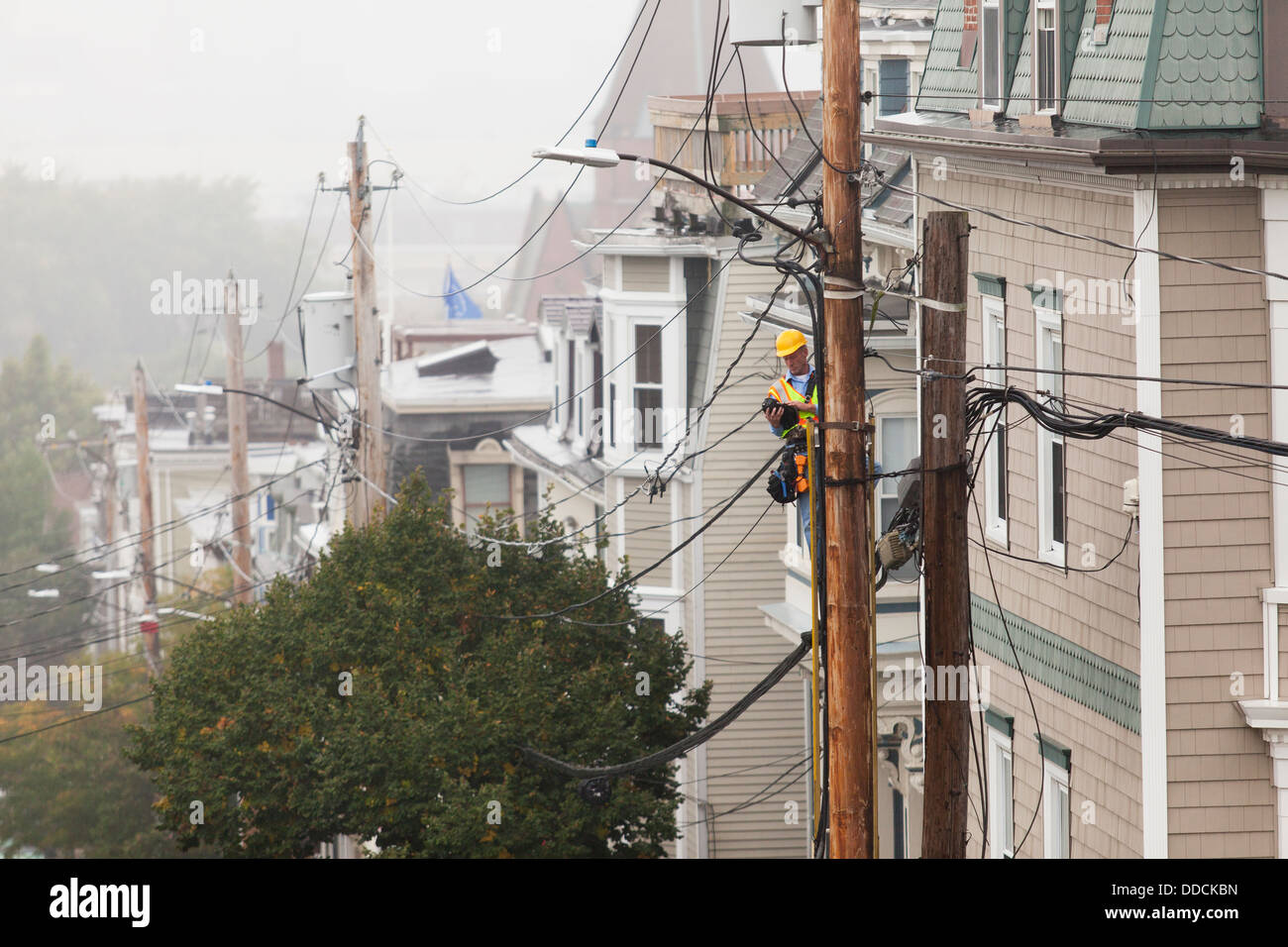 Cable lineman working from ladder on cable distribution wiring Stock ...