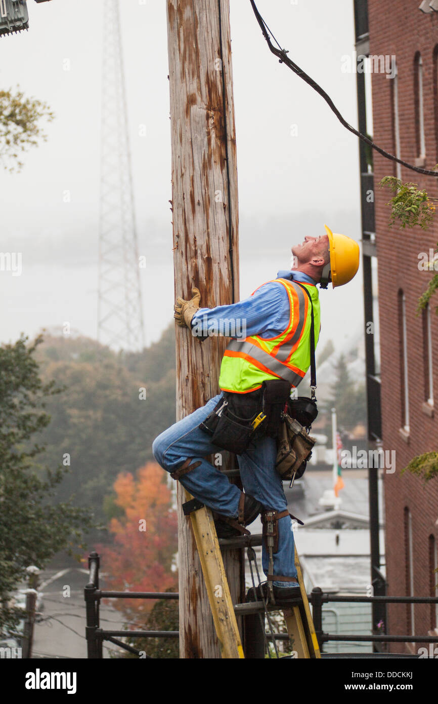 Cable lineman climbing up a ladder on city power pole Stock Photo Alamy
