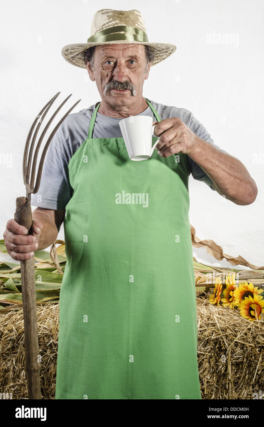 organic farmer with a pitchfork and a cup of coffee Stock Photo