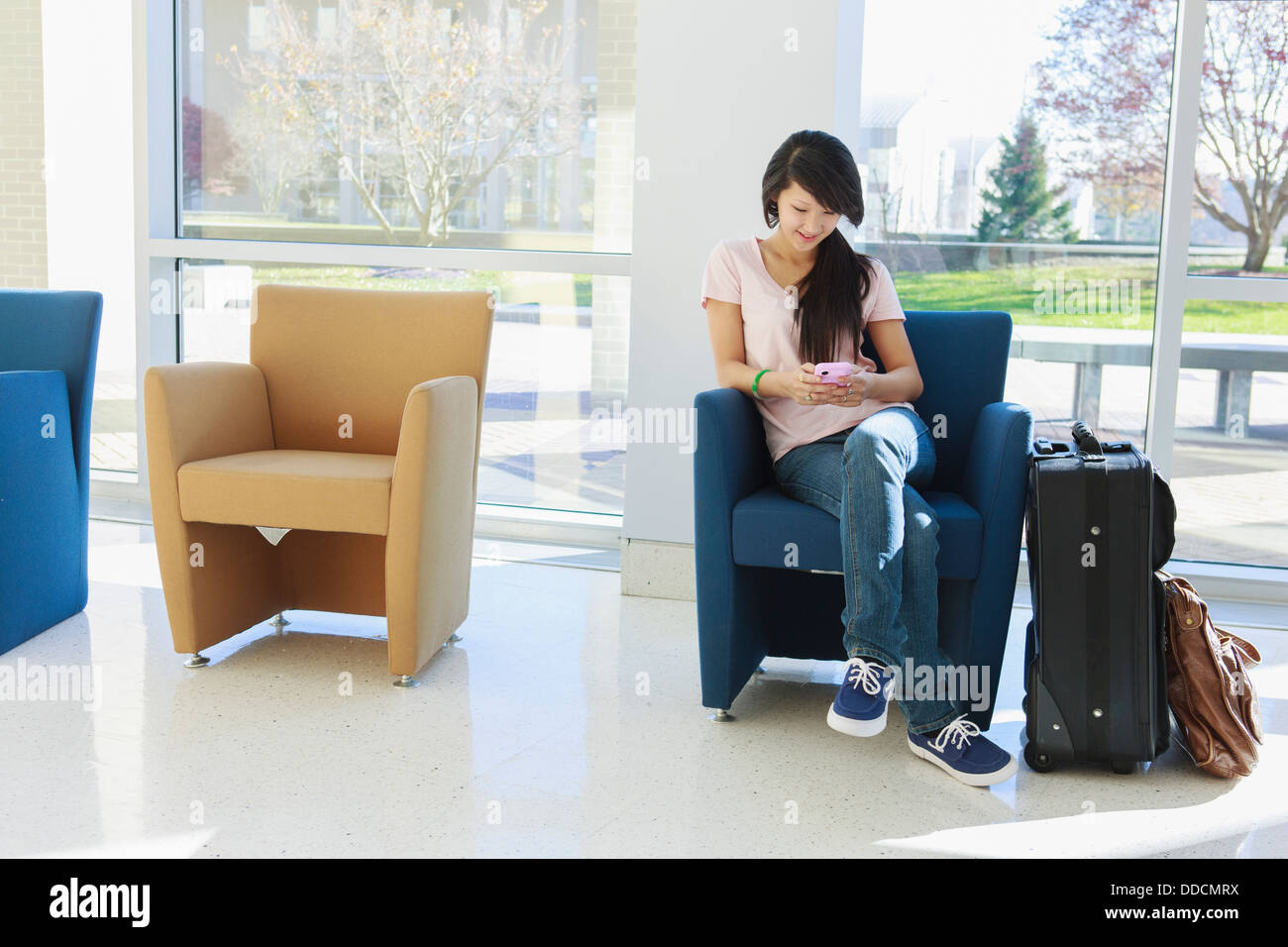 Girl Waiting In An Airport Lounge And Using Her Cell Phone